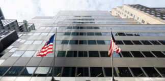 Modern skyscraper with BlackRock sign and American flags