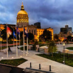 Capitol building with flags at dusk in cityscape