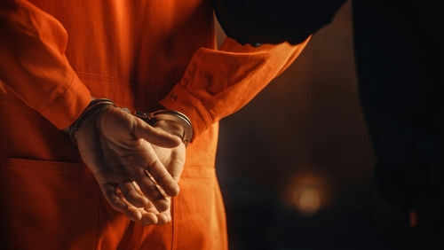 prisoner-extradition2056434941jpg Person in orange jumpsuit with hands cuffed behind back