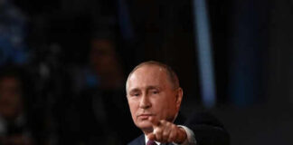 Person pointing while speaking at a podium