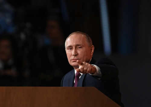 Person pointing while speaking at a podium
