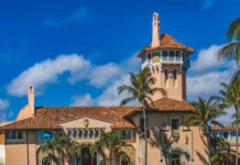 Shock Win in Mar-a-Lago’s Shadow: GOP Ousted Historic mansion with a tower surrounded by palm trees under a blue sky