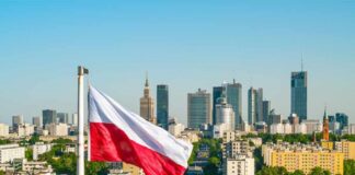 Polish flag waving in front of the Warsaw skyline