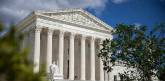 Supreme Court building with columns and a statue.