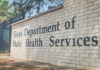 Sign for the Texas Department of State Health Services on a brick wall