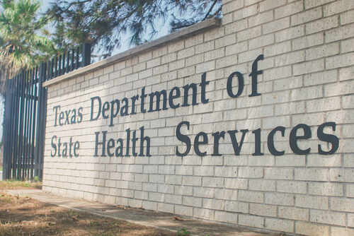 Sign for the Texas Department of State Health Services on a brick wall
