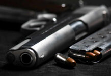 Close-up of a handgun and ammunition on a dark background
