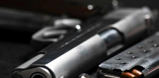 Close-up of a handgun and ammunition on a dark background