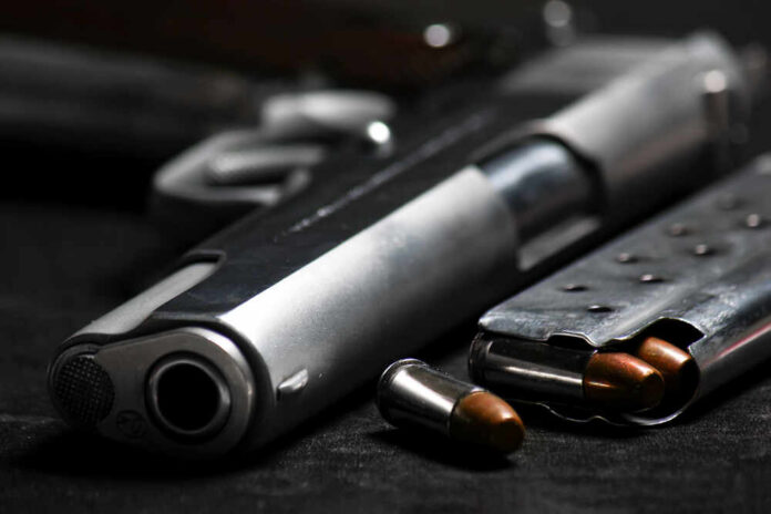 Close-up of a handgun and ammunition on a dark background