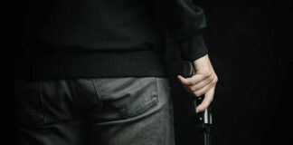 A person holding a gun with a dark background