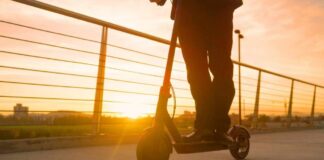 Person riding an electric scooter during sunset