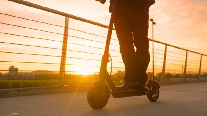 Person riding an electric scooter during sunset