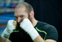 Fury vs. Joshua: Rivalry Reignites Amid Drama Boxer in training with hands wrapped, preparing for a fight