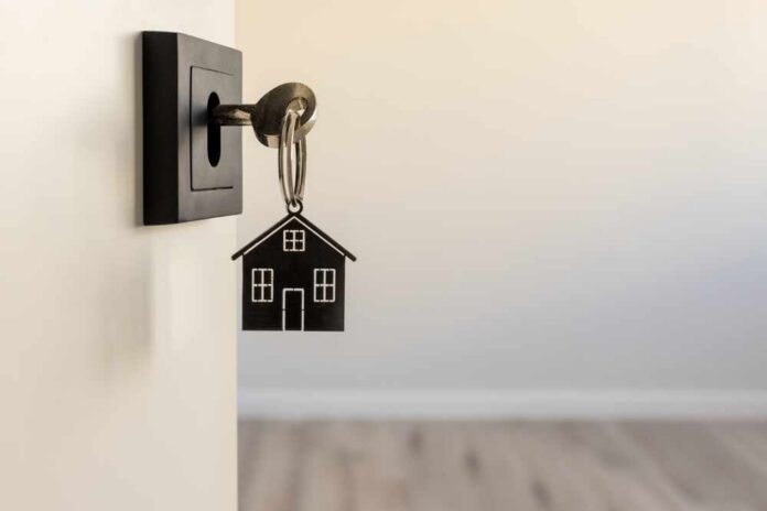 shutterstock_2599709733.jpg A key with a house-shaped keychain inserted into a door lock