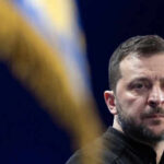 Energy Warfare: Russia-Iran Strategy Unveiled Person with short hair next to blurred yellow flag