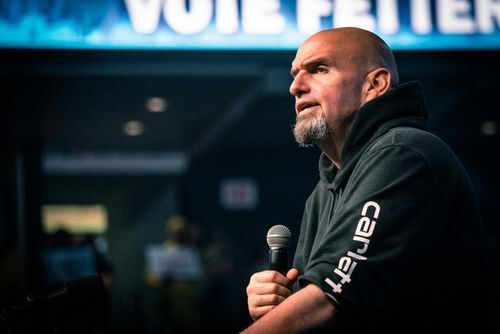 fetterman2231134317 Man speaking into microphone on stage.