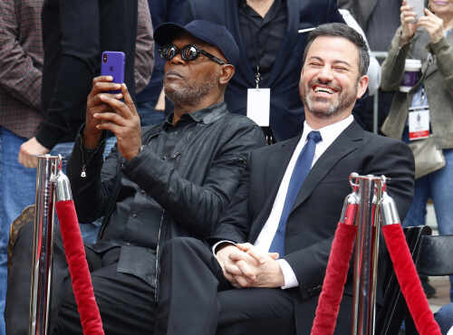shutterstock_1040899984.jpg Two men sitting together at a celebrity event, one taking a photo