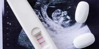 Pregnancy test next to an ultrasound image and two white pills
