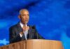 Obama Sounds Alarm: DOJ “Weaponized” Against Opponents A man in a suit delivering a speech at a podium with a blue starry background