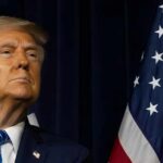 Iran War Backlash: Trump Faces Massive Disapproval A political figure looking confidently while standing near American flags
