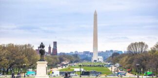 View of the Washington Monument from a park with a statue in the foreground
