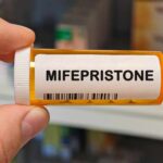 Alito’s Bold Move: Mail-Order Abortion Pills Stay A hand holding a prescription bottle labeled Mifepristone