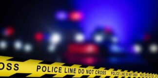 Yellow police tape reading 'DO NOT CROSS' at a crime scene