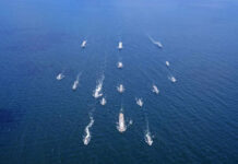 Aerial view of multiple naval ships operating in the ocean