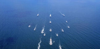 Aerial view of multiple naval ships operating in the ocean