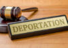 Gavel and sign reading Deportation on desk.
