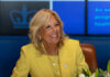 Smiling woman in a yellow blazer at a meeting table