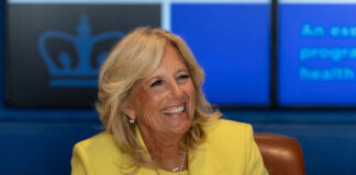 Smiling woman in a yellow blazer at a meeting table