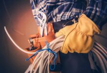 AI Is Coming, But These Jobs Aren’t Budging Electrician holding coiled cables with tool belt
