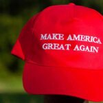 Red baseball cap with political slogan and small U.S. flag patch