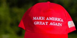 Red baseball cap with political slogan and small U.S. flag patch