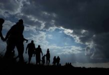 Europe’s Migration Strain Is Now Official Silhouettes of people walking under dramatic cloudy sky