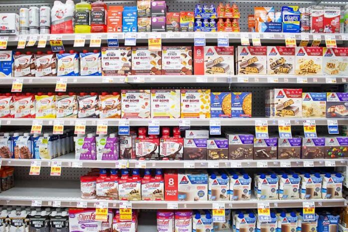 shutterstock_2026383434 Grocery aisle shelves with protein bars and shakes