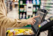 Shopper using self-checkout touchscreen in a grocery store