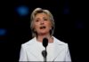 Hillary Goes Much Further Than the Evidence woman in white suit speaking at a microphone