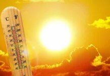 Record Heat Lingers – Autumn on Hold thermometer in front of a blazing sun and orange sky
