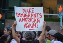 Protester holds a sign at a crowded street demonstration