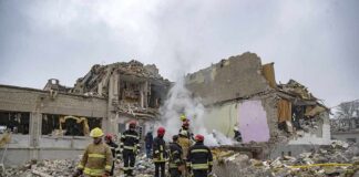 Firefighters search rubble of a partially collapsed building